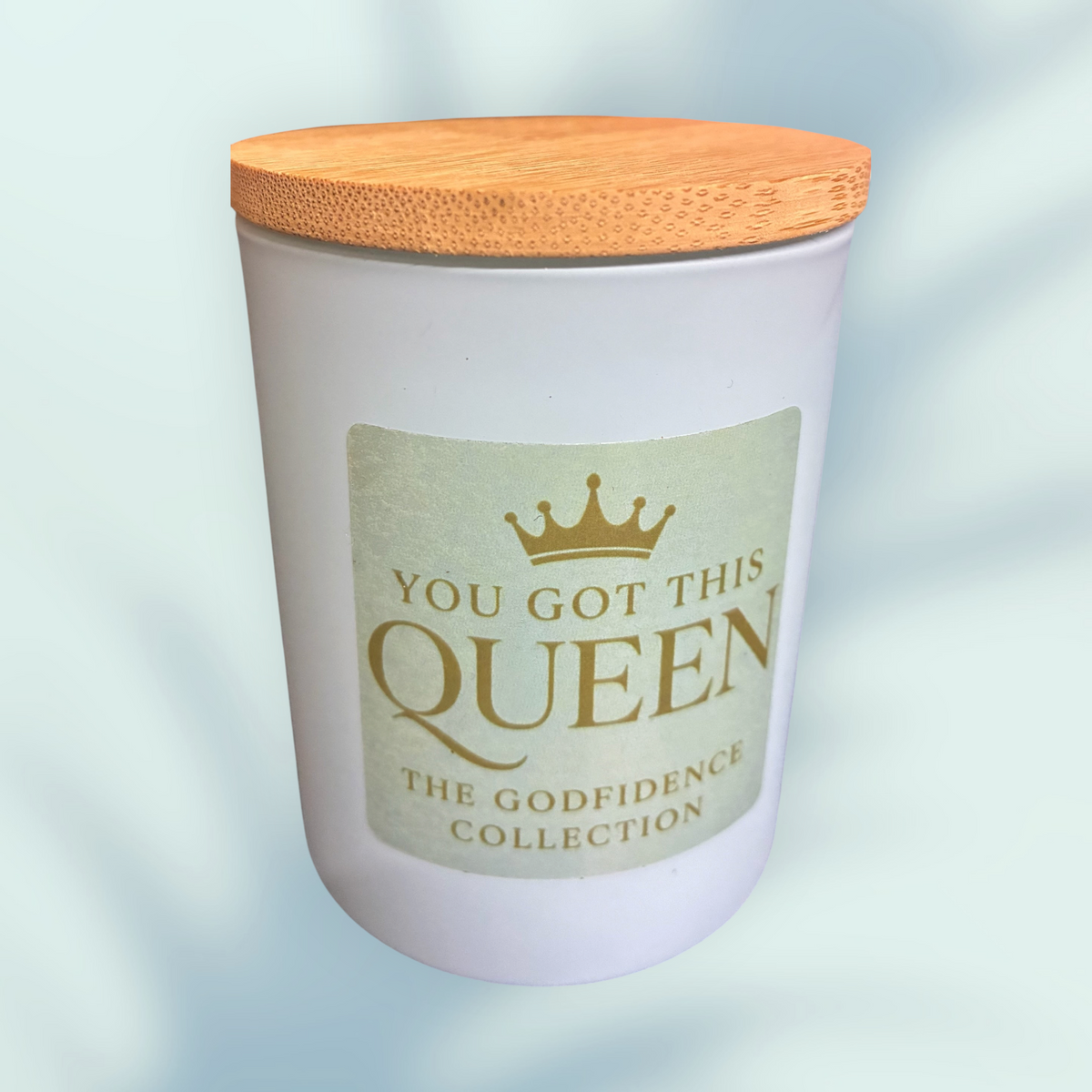 The Godfidence boutique llc white glass candle with a bamboo lid featuring the You Got This Queen inspirational label
