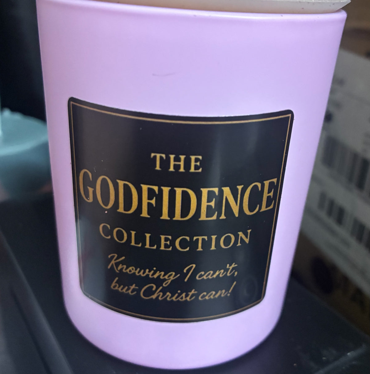 The Godfidence boutique llc lavender scented candle with black and gold label featuring inspirational faith quote